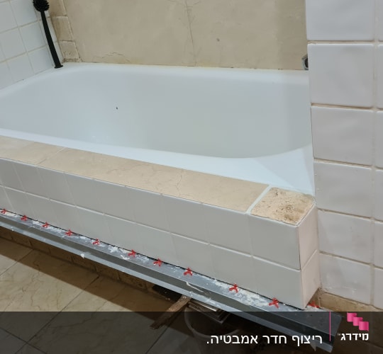אמבטיה עם אריחים חדשים בתהליך שיפוץ